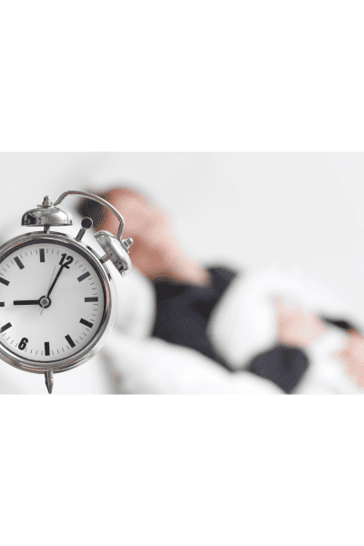 woman sleeping next to alarm clock