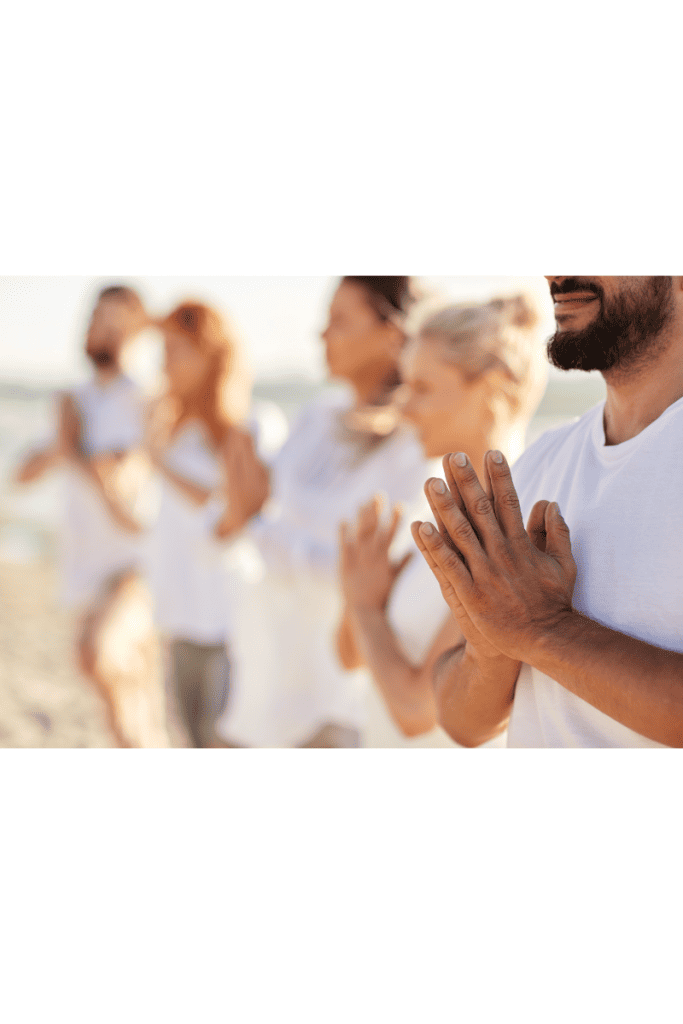 group of people meditating at the beach 