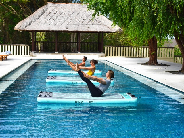 doing yoga on pool float in bali 